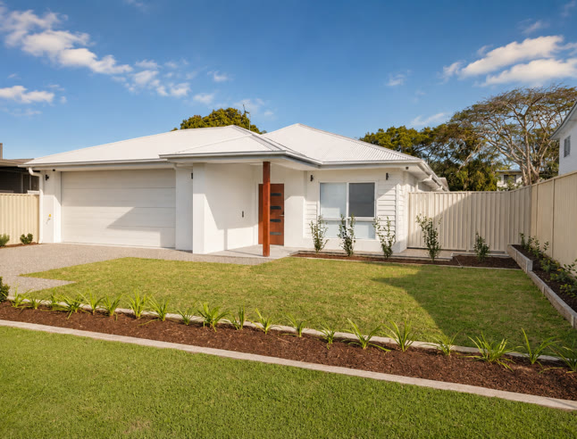 The front of the house seen from the footpath: single storey, white render, double garage, and a level concrete path running to a covered entry.